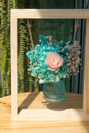 Dried flowers in glass container within a frame as a decoration motifの写真素材