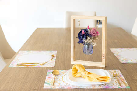 Plate with utensils, on the table decorated with a small flower arrangement