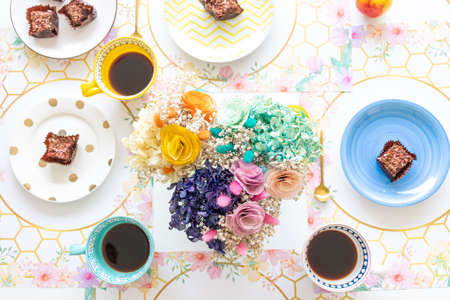Table top view with sweet snack and coffee with fresh flower centerpieceの写真素材