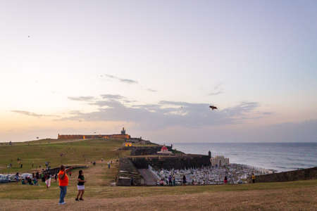 People and children are flying kites at sunsetのeditorial素材