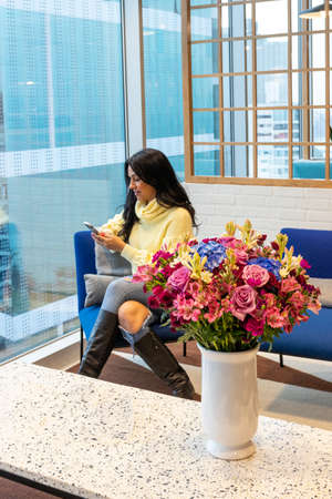 Brunette woman talking by phone from the comfort of your livingの写真素材