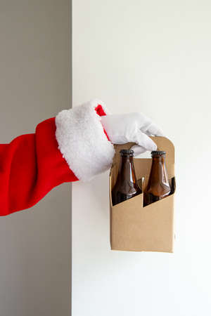 Santa Claus showing a 4 pack of craft beers