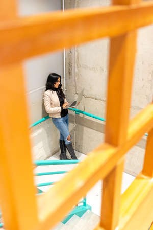Brunette woman is working with her laptop from the stairsの写真素材