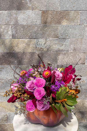 Floral arrangement of roses inside decorated pumpkinの写真素材
