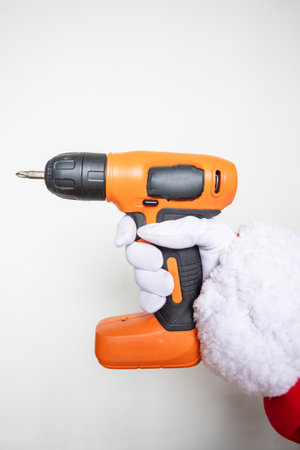 Santa Claus hands using an orange colored drillの写真素材