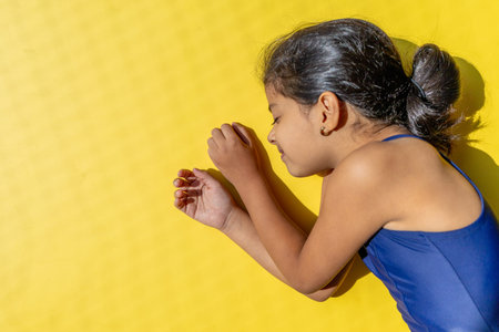 Little girl with a swimsuit is receiving the sun with direct light.