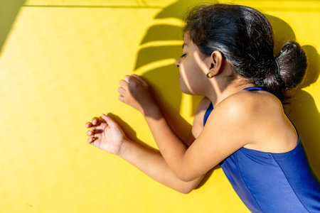 Little girl with a swimsuit is receiving the sun with direct light.