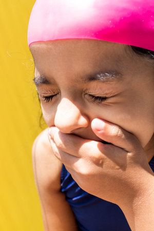 Little girl with a swimsuit is receiving the sun with direct light.