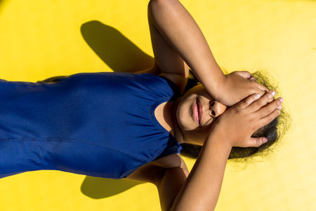 Little girl with a swimsuit is receiving the sun with direct light.