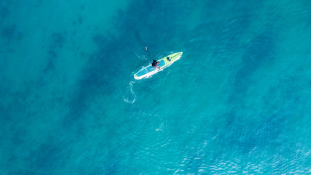 People practicing paddleboarding on the crystal clear turquoise shores