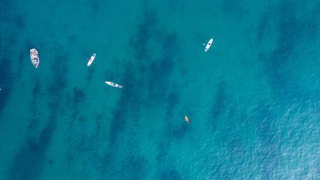 People practicing paddleboarding on the crystal clear turquoise shores
