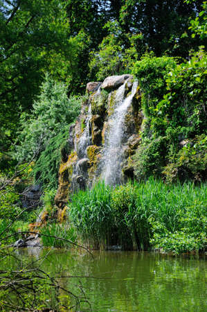 Water fall and a lake in Palmen Garten, Frankfurt am Main, Hessen, Germanyの写真素材