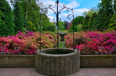 Beautiful well with pink azalea flowers in Keukenhof Park, Lisse in Holland.の写真素材