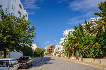 HAMMAMET, TUNISIA - Oct 2014: Street with date palms, trees and white buildings on October 6, 2014 in Hammamet, Tunisia.のeditorial素材