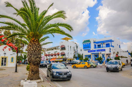 HAMMAMET, TUNISIA - Oct 2014: Street with date palms, trees and white buildings on October 6, 2014 in Hammamet, Tunisia.のeditorial素材