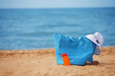 a photo of Packed beach bag on empty sand beachの写真素材