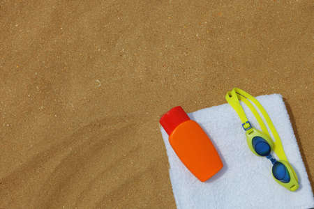 a photo of Goggles and sunblock on beachtowel