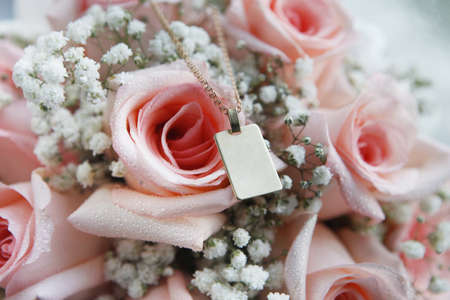 a close up of golden pendant with pink rosesの写真素材