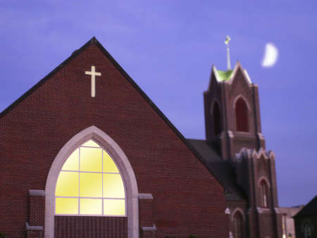 Moon over bell tower of catholic church at dusk.の写真素材