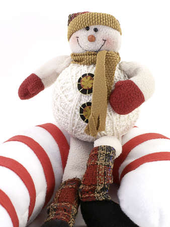 Crafted Snowman sits on giant candy-cane, with white background.の写真素材