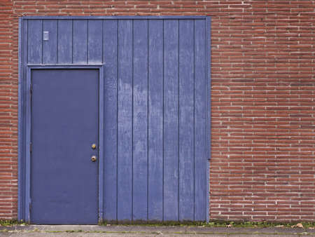 Blue door and frame in red brick wall.