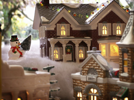 Snowman overlooks charming lights of Christmas villiage.の写真素材