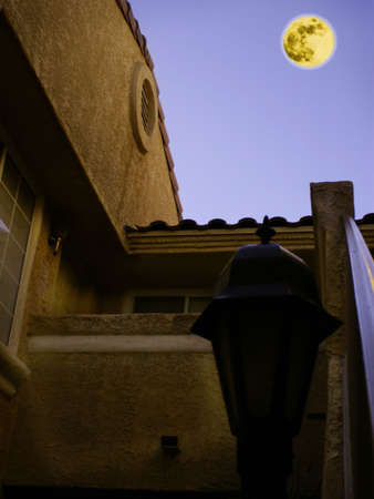 Adobe building in california desert lit by orange moon in purple sky.の写真素材