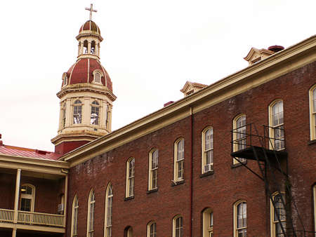 Architectural study of old (1870) red brick academy building with cupola and cross.の写真素材