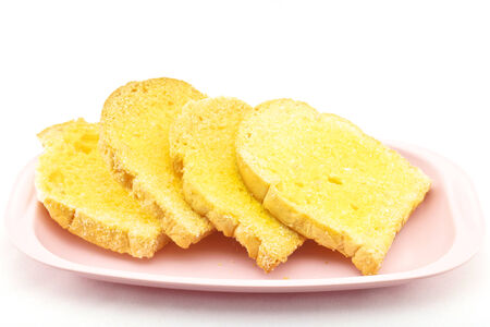 Bread baked with butter and sugar placed in a pink tray on white.