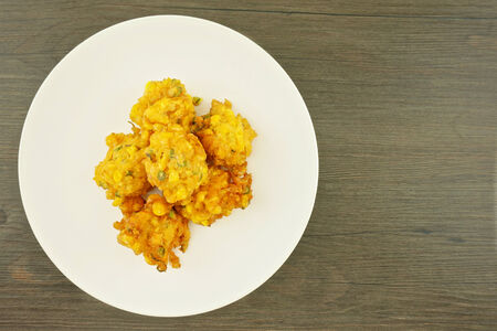 Fried corn nugget vegetarian food place on dish with wooden table 