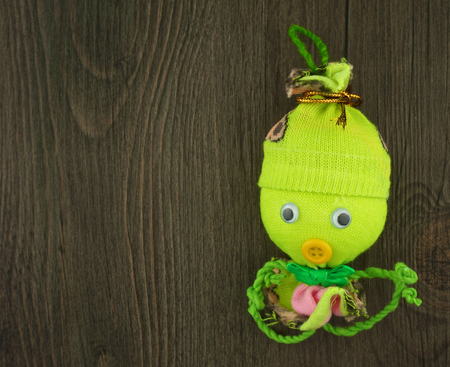 Green doll made from yarn with camphor aroma as octopus with wood background の写真素材