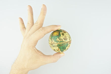 Hand of man make signal by ok with the globe isolated on white background.の写真素材