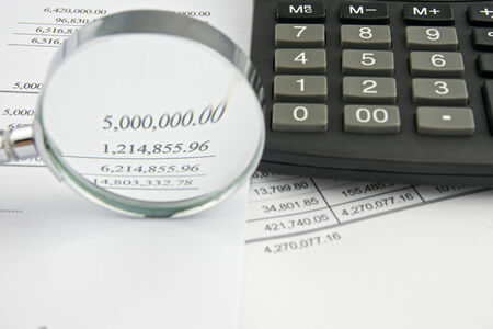 Document of account include balance sheet and sales with magnifier and black calculator.の写真素材