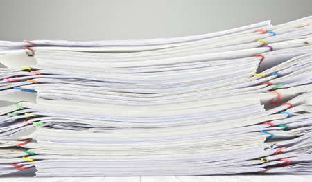 Pile of paperwork place on finance account on table near wall.の写真素材