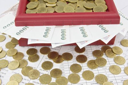 Gold coins and bill on red treasure box place on finance account.の写真素材