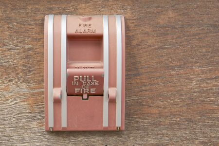 Old box of fire alarm on left with wood background.の写真素材