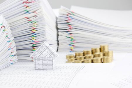 House on finance account have blur step pile of gold coins and pile of paperwork as background.の写真素材