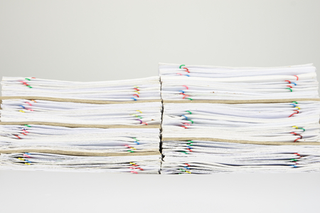 Pile of overload paperwork with colorful paperclip and envelope on white background.の写真素材