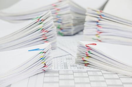 Pile document and blur pile overload paperwork of report and receipt with colorful paperclip place...