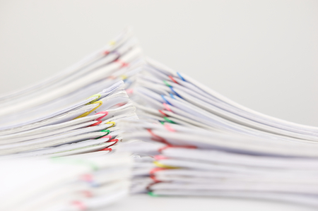 Pile overload paper of receipt and report with colorful paperclip have blur pile document foreground...