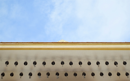 Row of bell on roof of temple Golden Mountain in Bangkok Thailand with blue sky and cloud.の写真素材