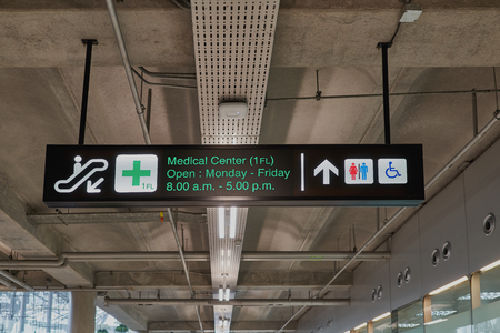 Medical center and toilets information board sign with green character on black background at international airport terminal.の写真素材