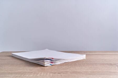 Pile document of report with colorful paperclip place on wood table and white background with copy...
