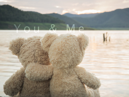 teddybears relaxing overlooking lake and mountainsの写真素材