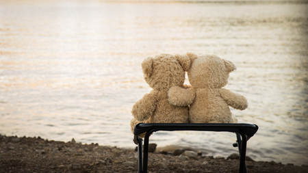 teddybears relaxing overlooking lake and mountainsの写真素材