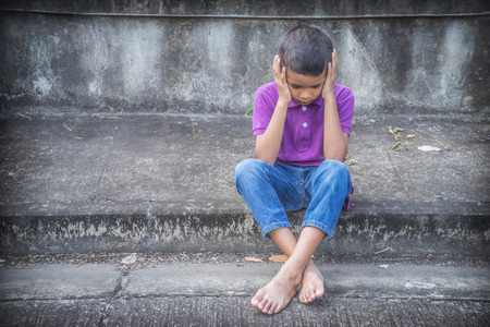 Young Asian homeless child looking scared, alone and in need of helpの写真素材