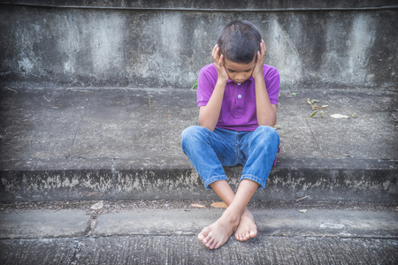 Young Asian homeless child looking scared, alone and in need of helpの写真素材