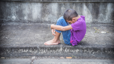 Young Asian homeless child looking scared, alone and in need of helpの写真素材