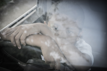 Young Asian boy trapped inside a carの写真素材