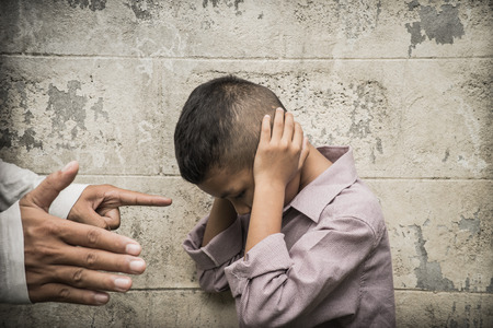 Young Asian boy being physically abused by someone older than himの写真素材